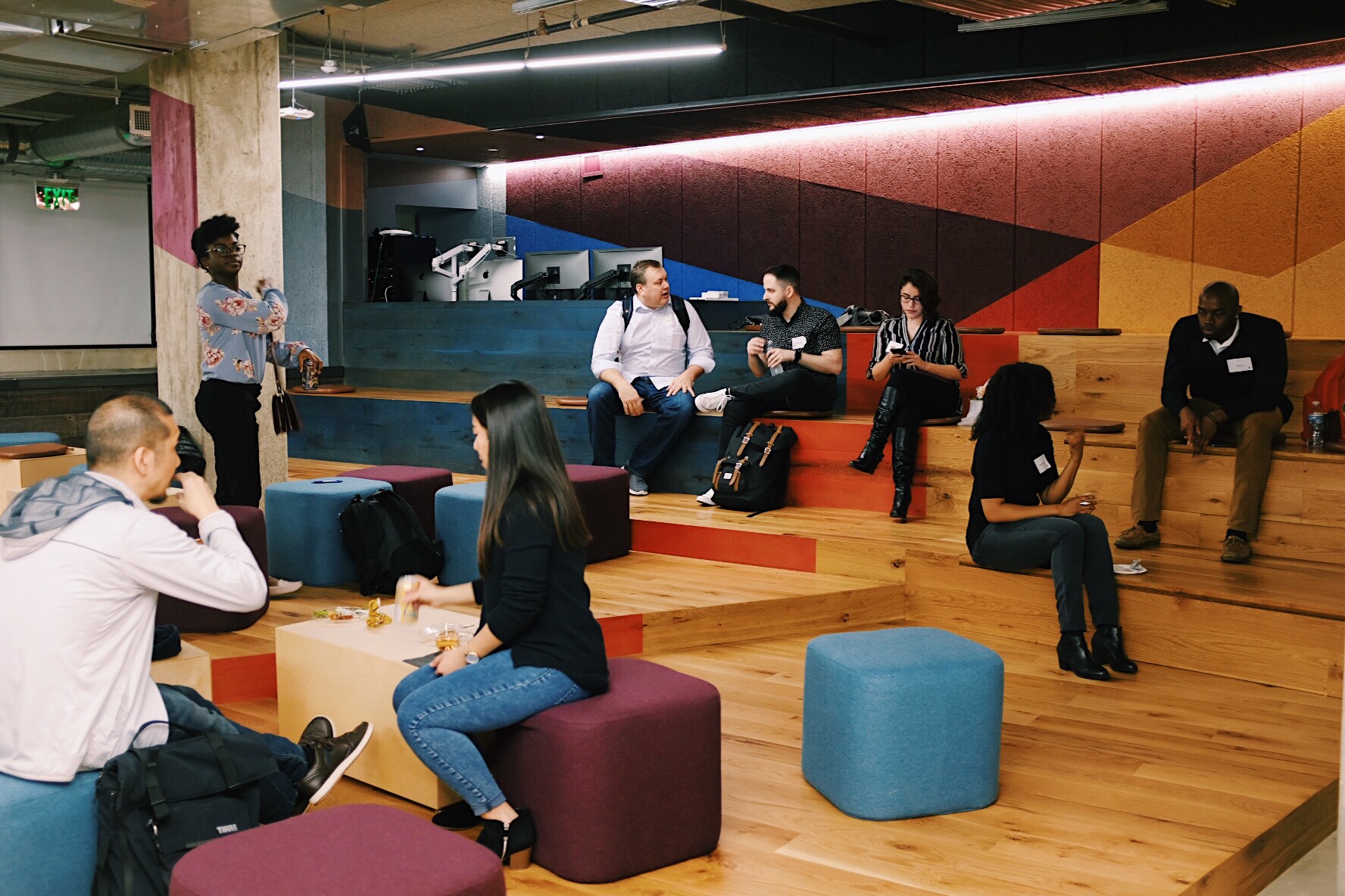 People sitting in stadium seating talking to one another