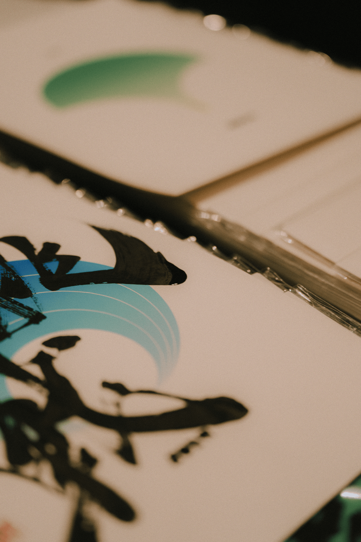 Close-up of colorful printed designs on cards, featuring Japanese characters abstract shapes and brush strokes.